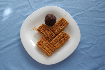 pieces of honey cake on a white plate with chocolate candy