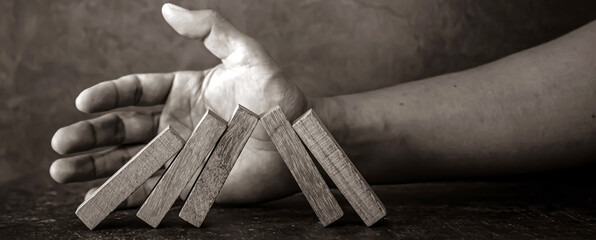 Hand prevent wooden block tower stack crash or fall domino. concept of prevention of financial...