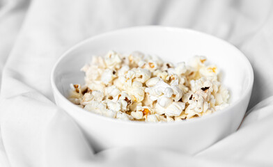 Close-up of a plate of popcorn in bed in the morning.
