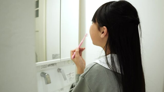 歯磨きをする小学生の女の子
