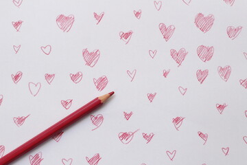 Red crayons are placed on a heart-shaped background drawn from crayons.