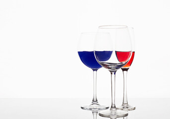 Wineglasses on the mirror. red and blue liquids in glasses