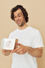 Cheerful man in a white t-shirt with a gift box