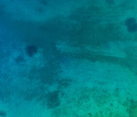 Aerial top view of sea waves hitting rocks on the beach with turquoise sea water. Amazing rock cliff seascape in the Portuguese coastline. Drone shot.