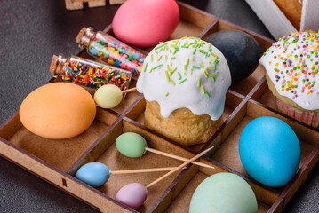 Festive cakes with white glaze, nuts and raisins with Easter eggs on the festive table