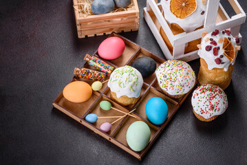 Festive cakes with white glaze, nuts and raisins with Easter eggs on the festive table