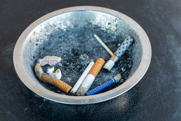 Cigarette butts in an ashtray. View from above. Close-up. Health problems from smoking, abstinence from smoking.