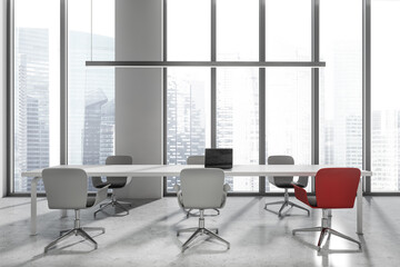 Business room interior with seats, table with laptop. Window with city view