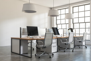 Corner view on bright office interior with desks with desktops