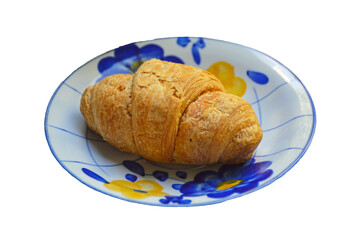 breakfast croissant on a small dessert plate on a white background. French national pastry. tasty and healthy breakfast concept