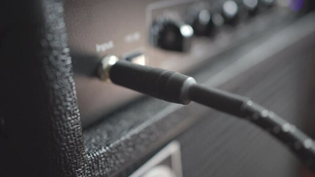 Connect an instrument cable jack into a bass guitar amplifier