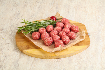 Raw uncooked beef meatballs served rosemary