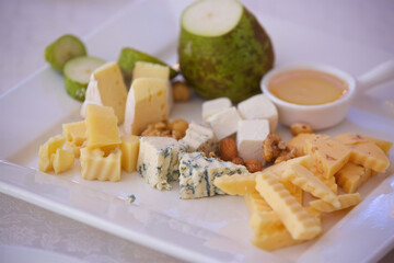 Different assortment of cheese on a plate. Menus for restaurants and cafes. Decoration with various ingredients.