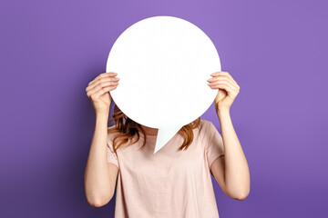 Student with blank white speech bubble isolated on purple studio background. copy space. woman...