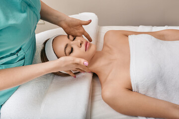 Fototapeta premium Pretty woman getting facial and head massage at wellness spa. Face massage with perfect clean and fresh skin, close-up