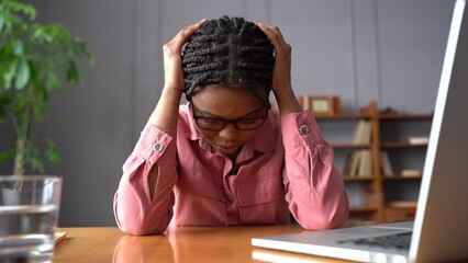 Unhappy african american businesswoman trying to cope with nervous tension or anxiety at workplace. Woman suffering from panic attack or headache. Girl in depression from stress and problems at work