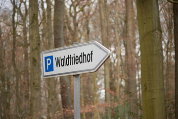 German sign showing direction to the parking area of a cemetery in the forest