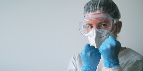 Copy Spce Portrait of a Doctor in a one-time protection suit, mask, goggles, blue gloves on his...