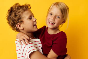 picture of positive boy and girl cuddling fashion childhood entertainment on colored background