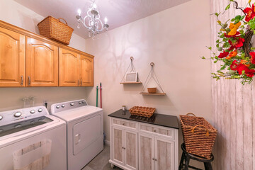 Craftsman laundry room with cabinets and hanging shelves