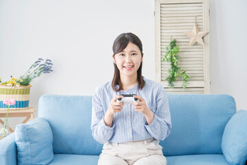 Obraz premium 女性 テレビゲーム 笑顔 リビング