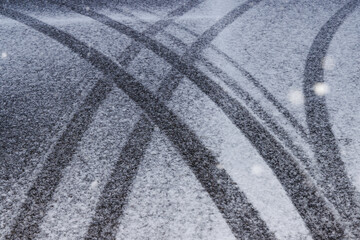 雪の積もる道路についたタイヤの跡