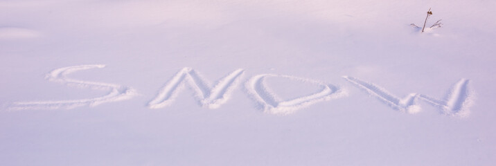 The inscription on the snow: SNOW. Early morning in winter.