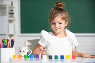 Little girls drawing a colorful pictures with pencil crayons in school classroom. Painting kids. Little funny artist painting, drawing art.
