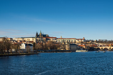View of Prague Castle and St. Vitus Cathedral with blue sky across the Vltava River with Charles Bridge. High quality photo