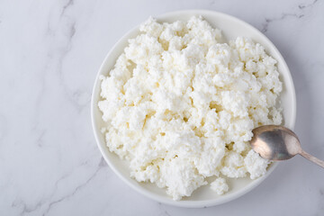 Bowl with fresh cottage cheese on table. Space for text