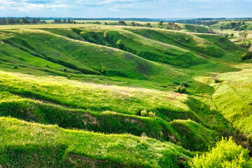 Hills slopes overgrown with green grass, nature reserve Ukrainian Iceland near Vasylkiv, Ukraine. Aerial view