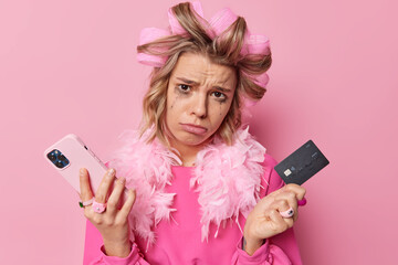 Discontent crying woman uses smartphone and credit card pays for good and online services via...