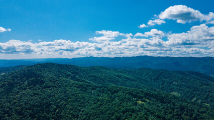 Fototapeta premium mountains aerial view in blue sky clouds
