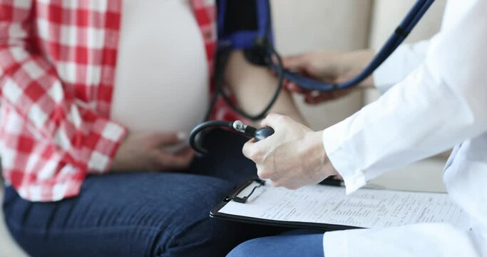 Doctor measuring blood pressure to pregnant woman closeup 4k movi