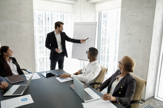 Corporate mentor, coach teaching interns, employees at modern office meeting workspace. Ambitious business leader, boss presenting marketing sales report to team of managers, stakeholders