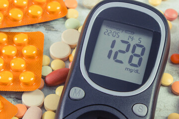 Glucometer with result of sugar level, fresh fruits and medical pills. Diabetes and healthy...