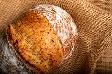 Wholemeal sourdough bread isolated on burlap cloth.