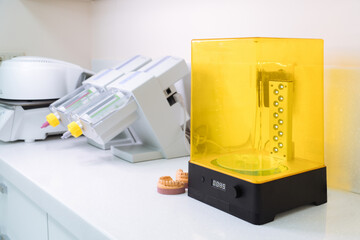 Device for washing a dental 3d print in a cleaning solution, and curing the mold using UV light. 