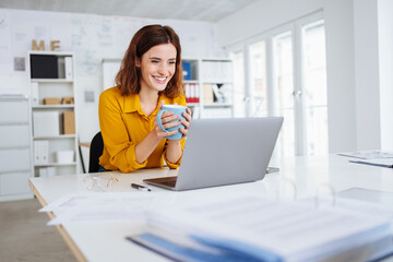 Young businesswoman sitting relaxing with a mug of coffee