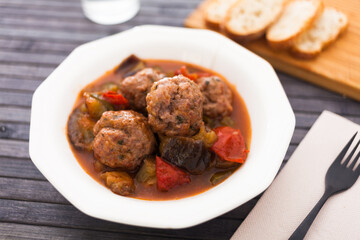 cooked meatballs with stewed eggplant in bowl