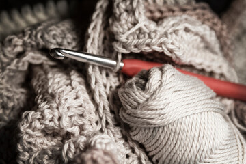 Yarn art, fiber art, crochet hook with stitches and skein of yarn