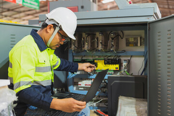 The factory's electrical engineers wear green protective clothing and plastic caps. Use laptops and...