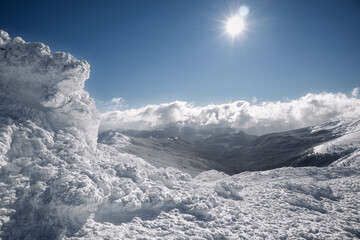 Fototapeta na wymiar High in the mountains, a large piece of ice merges with the clouds