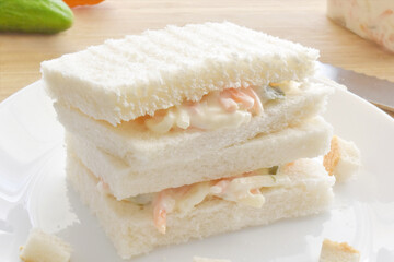 Creamy coleslaw sandwich on a white plate. 