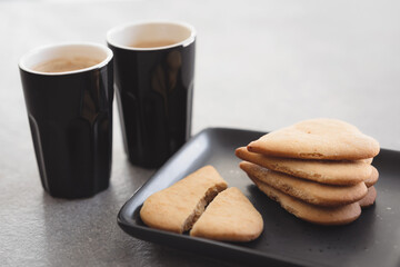 Heart shaped biscuits, butter cookies and coffee. Broken heart – first love or break of relations? Do what you love? Valentine’s Day concept.