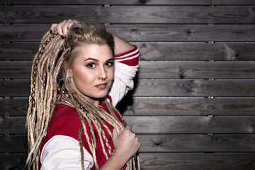 pretty blonde woman with dreadlocks touching her hair