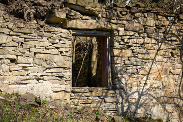 Wall of abandoned old stone house in Slovak mountain village