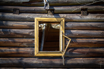 Window of abandoned old log house in Slovak mountain village