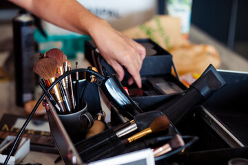 Dedicated focus Make-up converter on makeup artist's table with lots of makeup artist tools. The stack surrounds the makeup artist's table, leaving room for text.