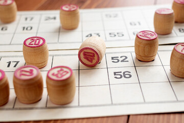 A lotto or bingo board game. Wooden barrels on game cards. The concept of leisure at home